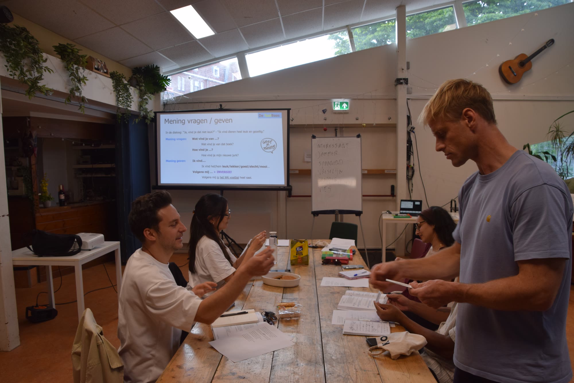 Tim geeft een interactieve Nederlandse les aan een groep studenten